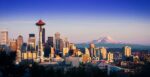 The Seattle city skyline with Mount Rainer in the distance on the right and the Seattle Needle in the foreground on the left.